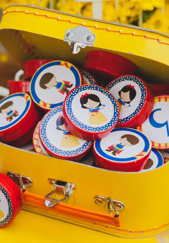 Latinhas personalizadas com os personagens da Branca de Neve. Coloque todas dentro de uma mala.