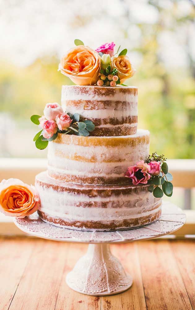 A festa de noivado simples pode contar com um bolo, como sugere o naked cake florido da imagem