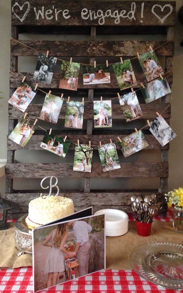 O painel de pallets com fotos ficou incrível nessa decoração de noivado simples