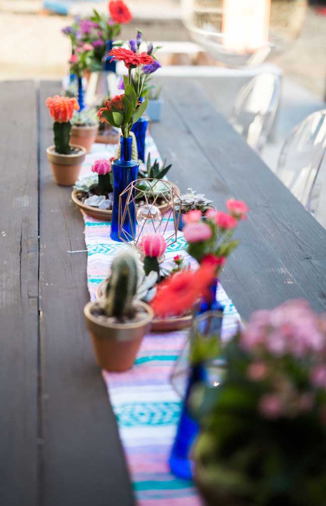 Flores e cactos decoram o centro da mesa da festa de noivado; opção para quem deseja algo rústico, colorido e alegre