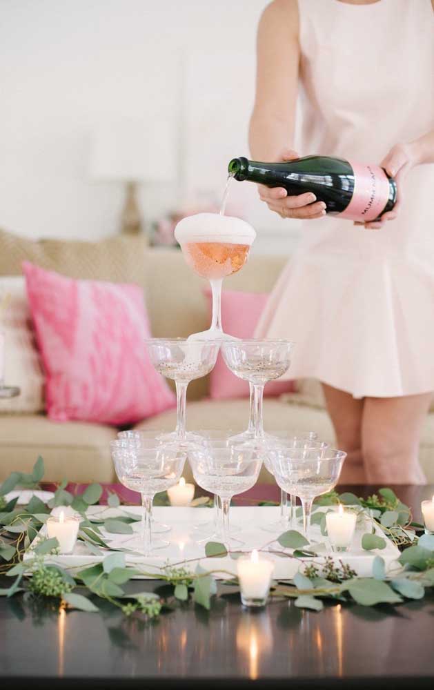 Uma ideia tradicional e que ainda faz muito sucesso em festas de noivado: pirâmide com as taças de champagne