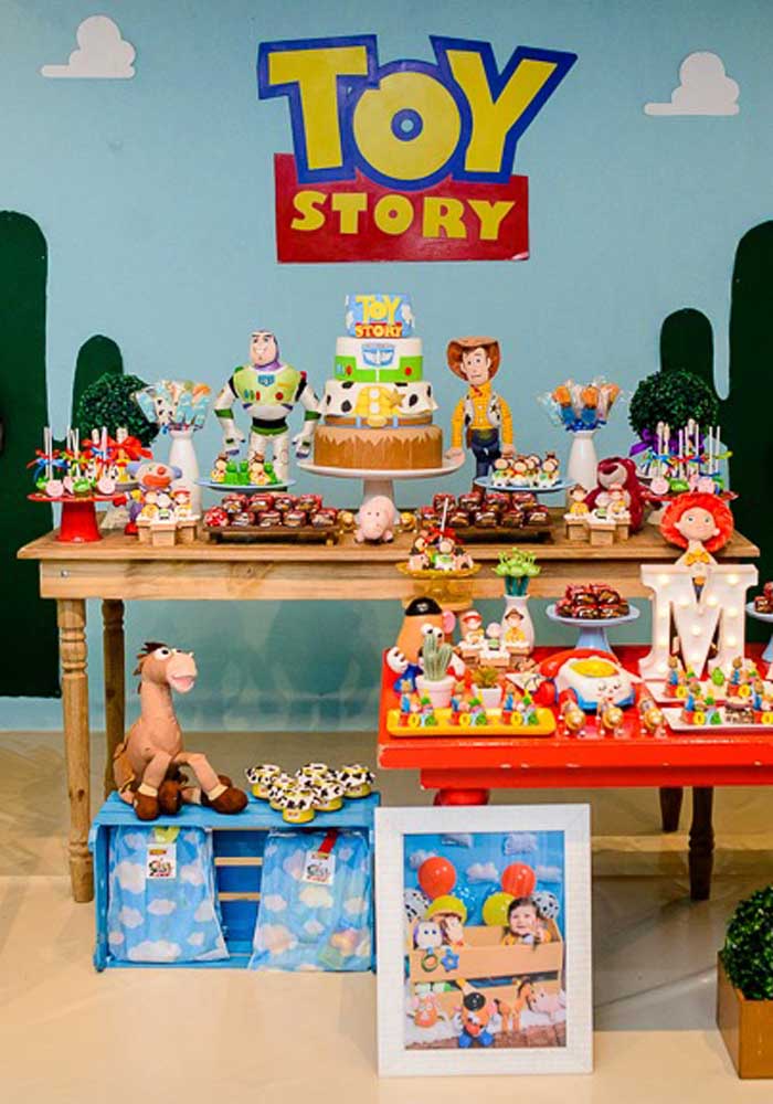 Você pode usar papel de parede para fazer o fundo Toy Story combinando com a decoração da mesa principal.