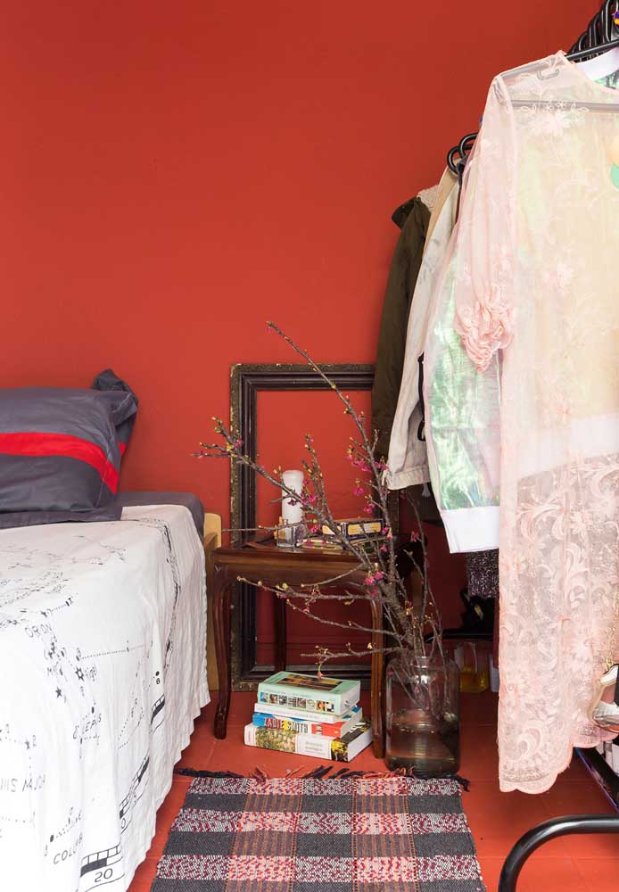 Roupas de cama, tapete e até um vaso com flores são perfeitos para inserir a cor vermelha na decoração.