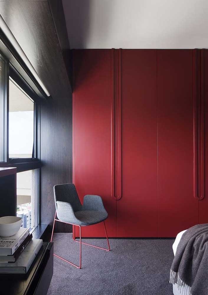 Para quebrar a seriedade do quarto cinza, você pode inserir um armário na cor vermelha.