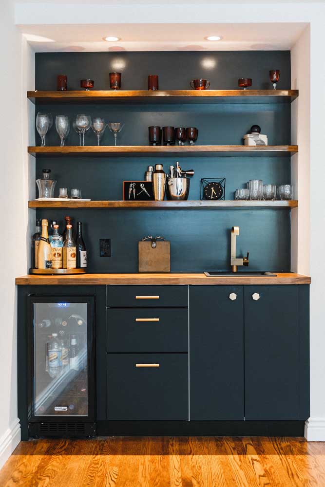 Que tal pintar a parede de tinta lousa azul para combinar com os móveis?