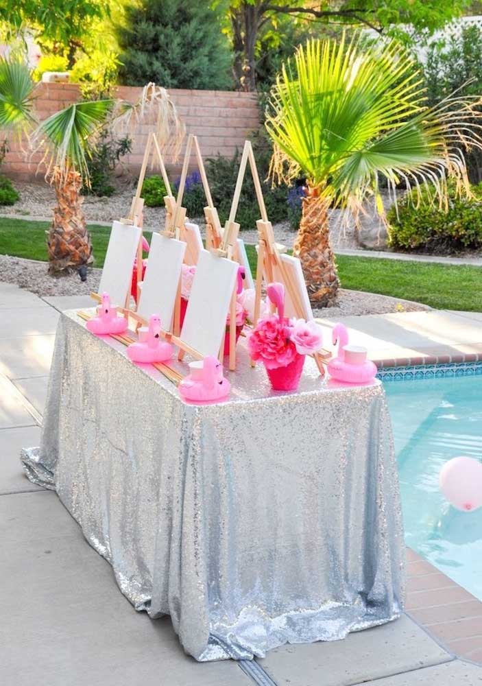 Mesa pronta para comemorar o aniversário com o tema flamingo na piscina.