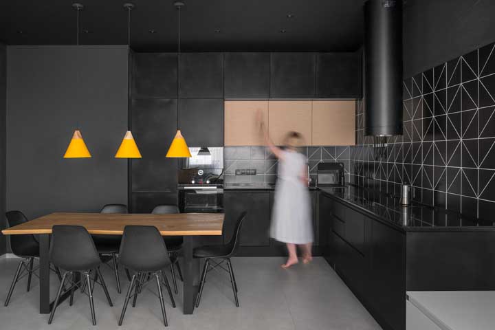 Para acompanhar a estética da cozinha, a opção foi por azulejos pretos com detalhes suaves em branco