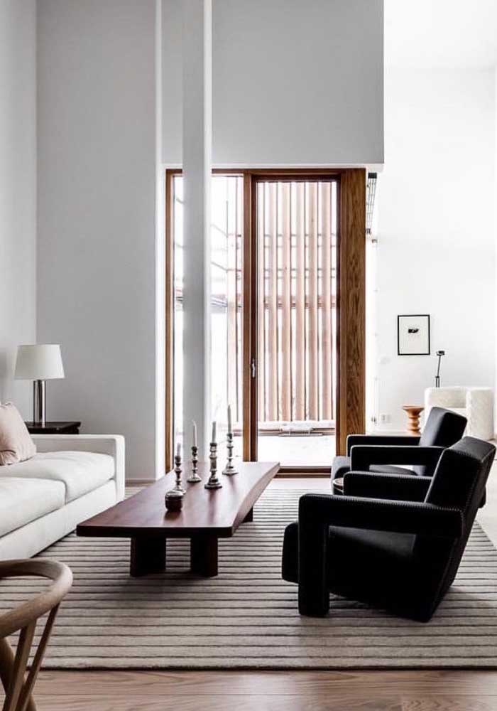 Poltrona decorativa preta complementando o visual moderno da sala de estar