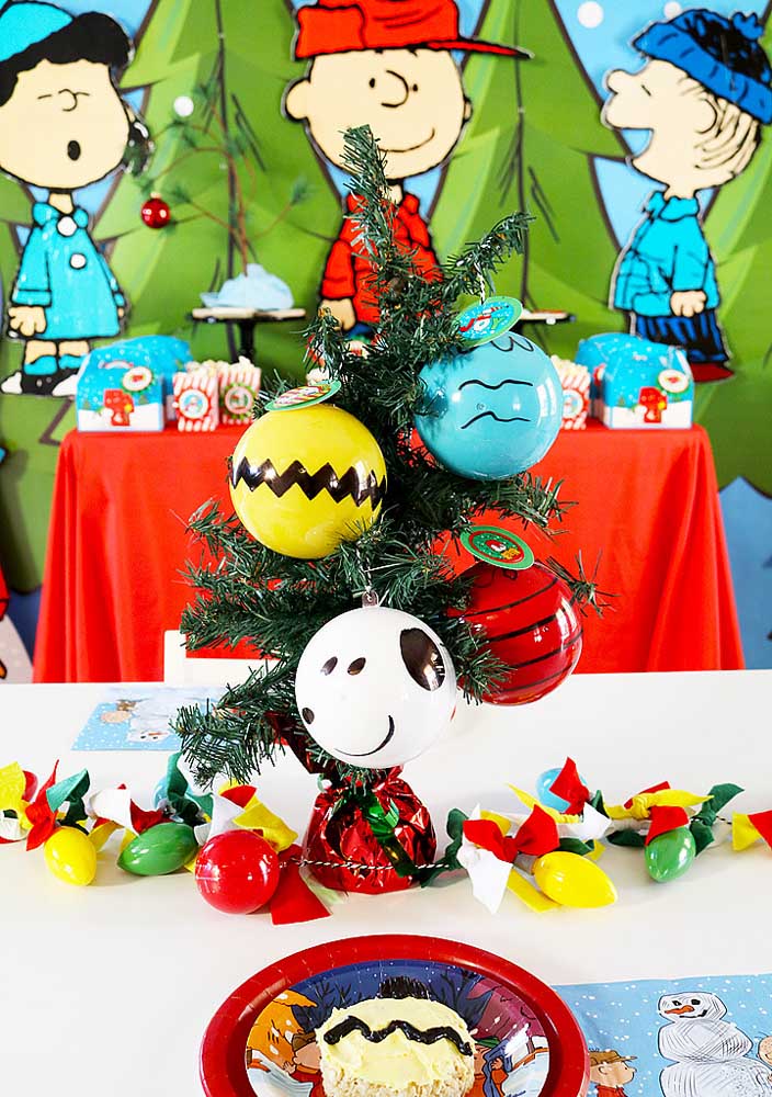 Balões da turma do Snoopy adornando a decoração simples da mesa do bolo