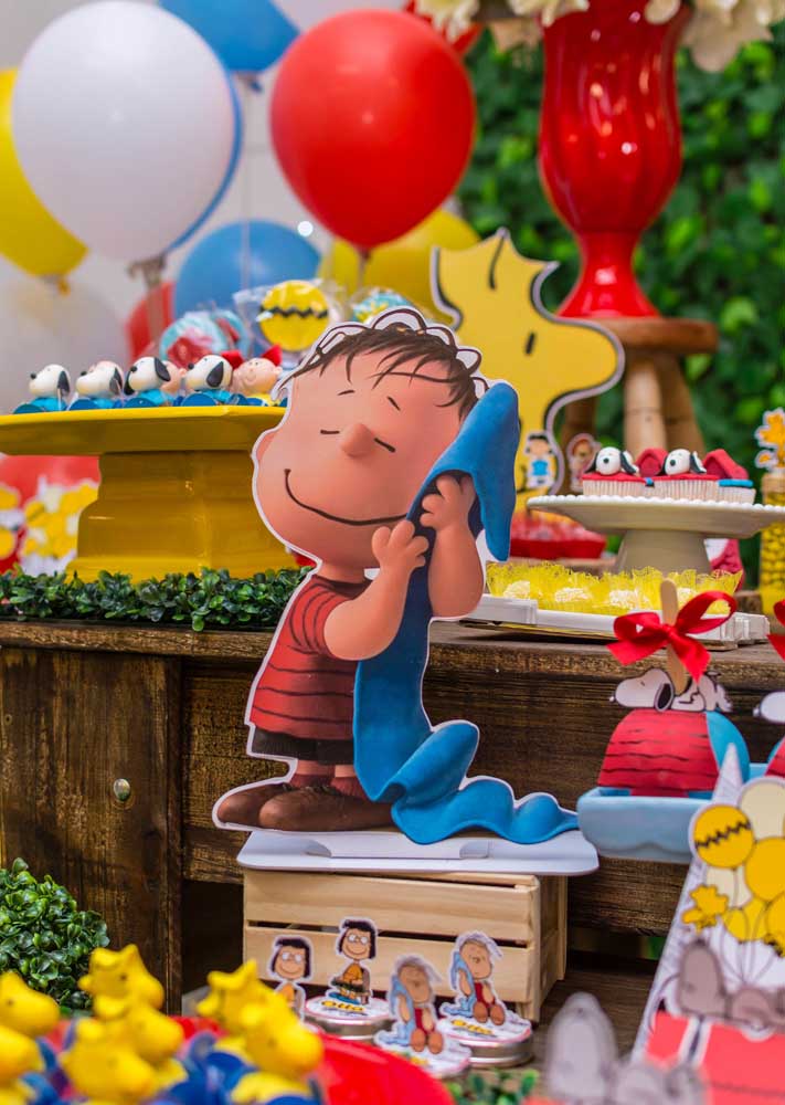 Madeira, grama e caixotes para deixar a decoração da Festa Snoopy mais aconchegante
