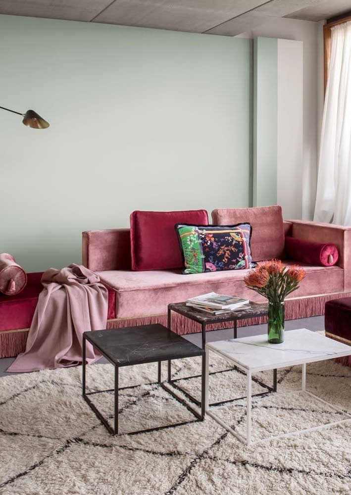 Sala decorada com sofá rosa em uma proposta de tom sobre tom 