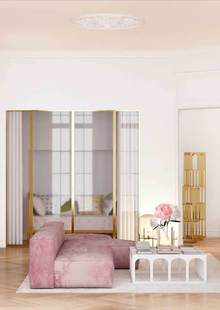 Os tons de dourado realçam a sofisticação do sofá rosa de veludo 