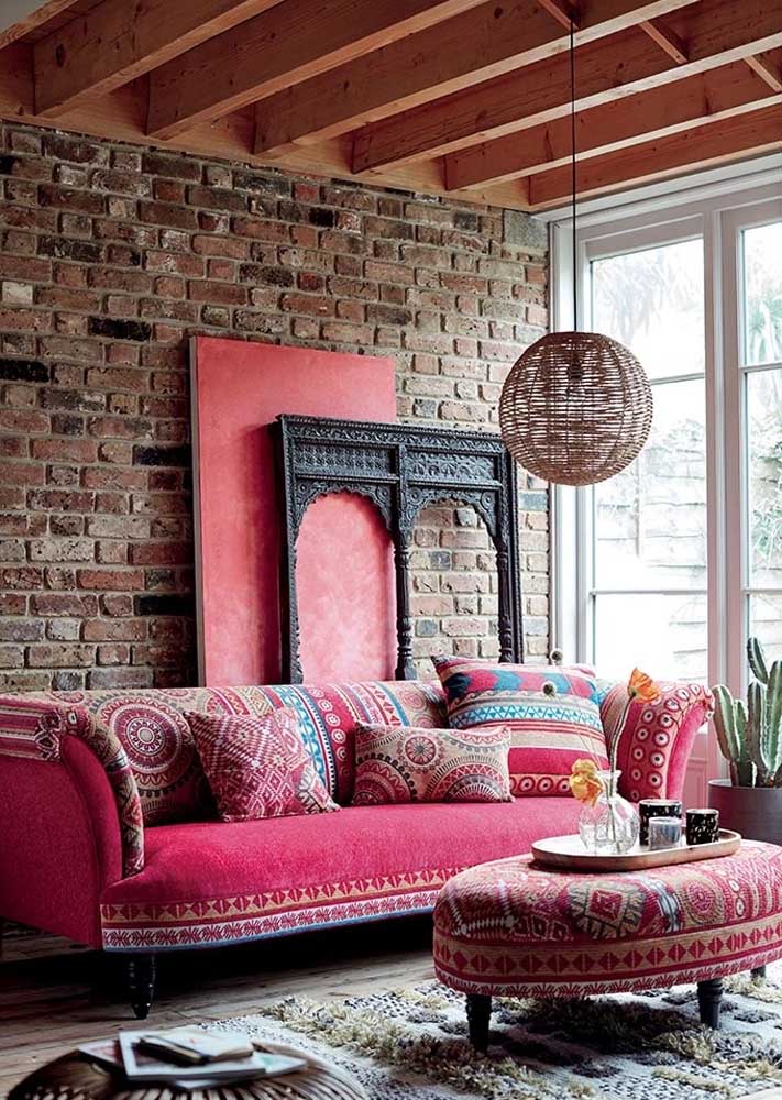Aqui, o sofá rosa vintage é o destaque da decoração da sala rústica 