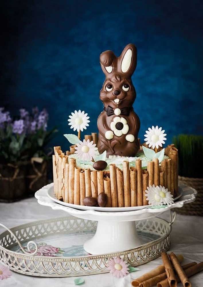 Bolo de páscoa decorado com um coelho de chocolate gigante. A cerquinha de canudinhos é outro destaque do bolo