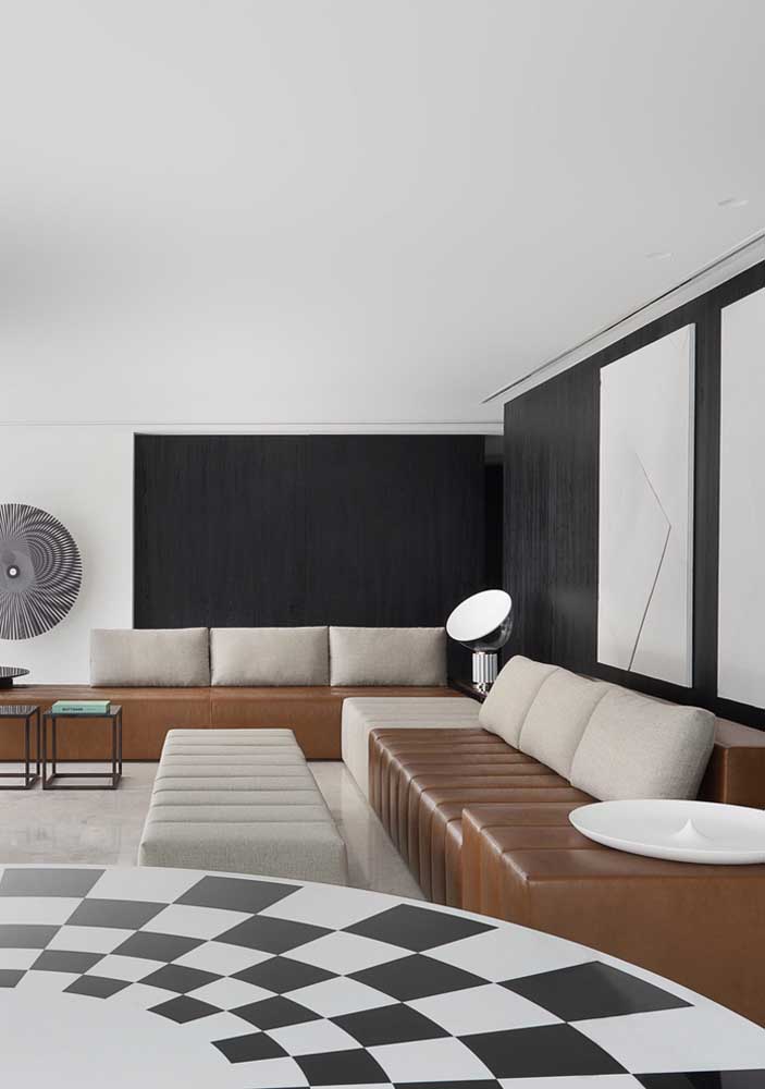 Já para essa outra sala moderna, a dica é investir em um sofá de canto sem braços em couro de duas cores