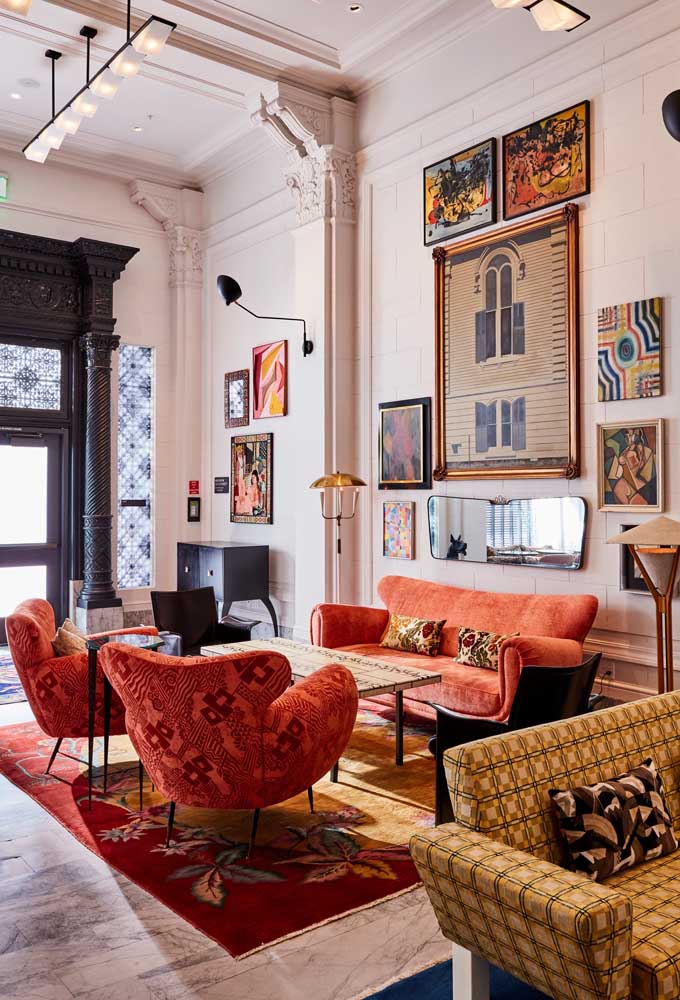 Conjunto de sofá e poltronas cor coral na decoração maximalista da sala de estar 