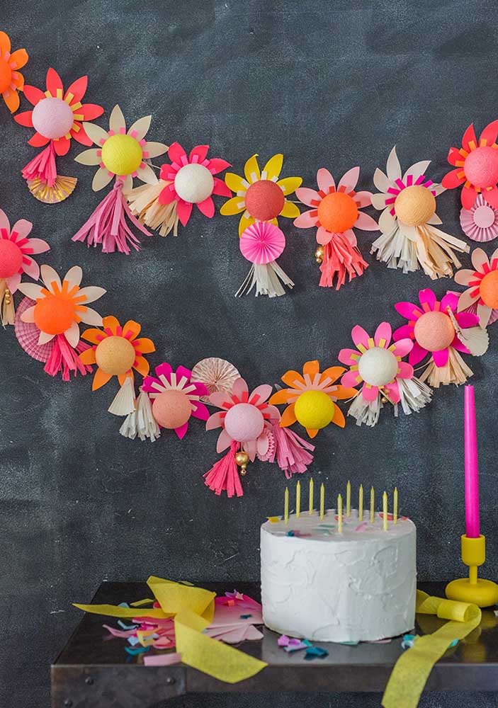Já aqui, a dica é fazer um cordão com flores do campo de papel para enfeitar o painel de aniversário