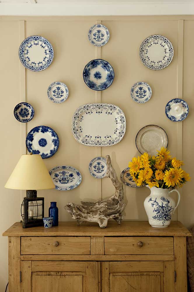 Composição com pratos na parede. O azul e o branco predominam no conjunto 
