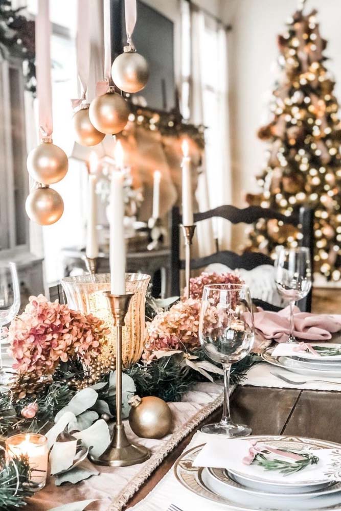 Decoração de mesa de ceia de natal com flores, bolinhas e velas