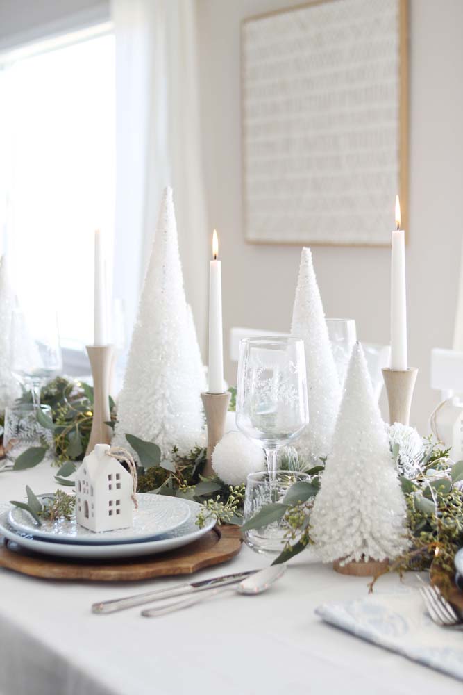 Decoração de mesa de natal simples e sofisticada onde o branco predomina em um leve contraste com o verde e dourado 