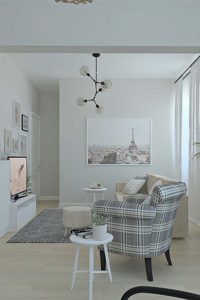 Decoração de sala de estar simples em estilo clássico. Repare no uso das cores neutras e de elementos tradicionais, como o xadrez