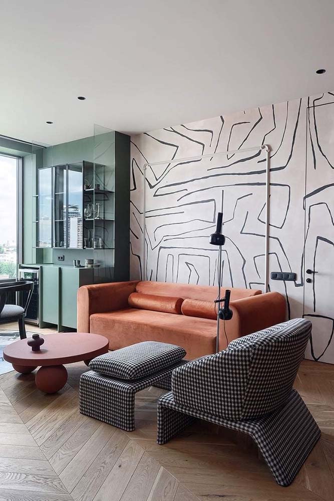 Um papel de parede para sala de estar com estampa abstrata combinando com a decoração
