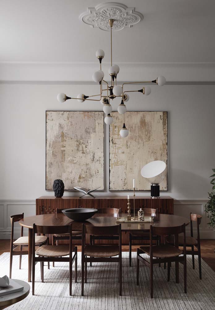 A parede cinza claro com boiserie em contraste com a mesa de madeira é um luxo só!