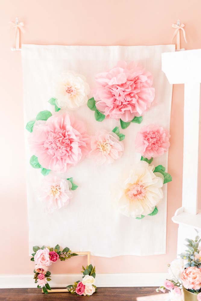 Um painel totalmente feito de tecido e não-tecido com flores rosas e pêssegos gigantes de TNT. 