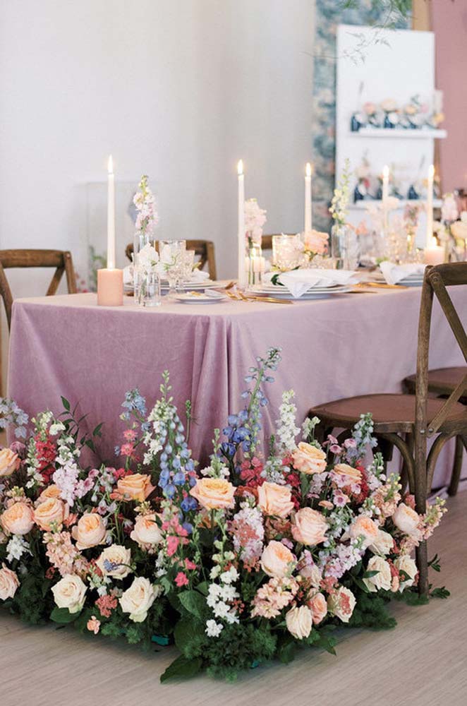 Toalha rosé de TNT na decoração de mesa com muitas flores.