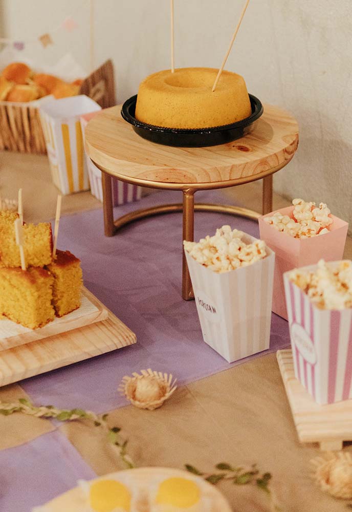 Corte duas cores de TNT em quadrados grandes para fazer uma toalha de mesa xadrez especial para festa junina.