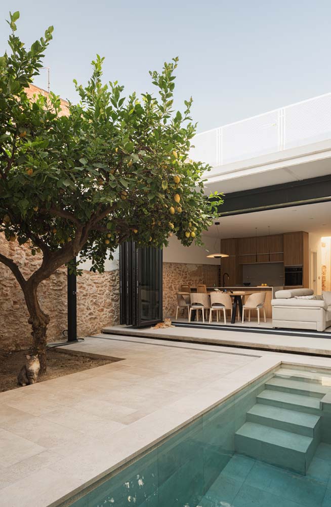 Área gourmet com piscina simples e um jardim para garantir momentos ainda mais relaxantes