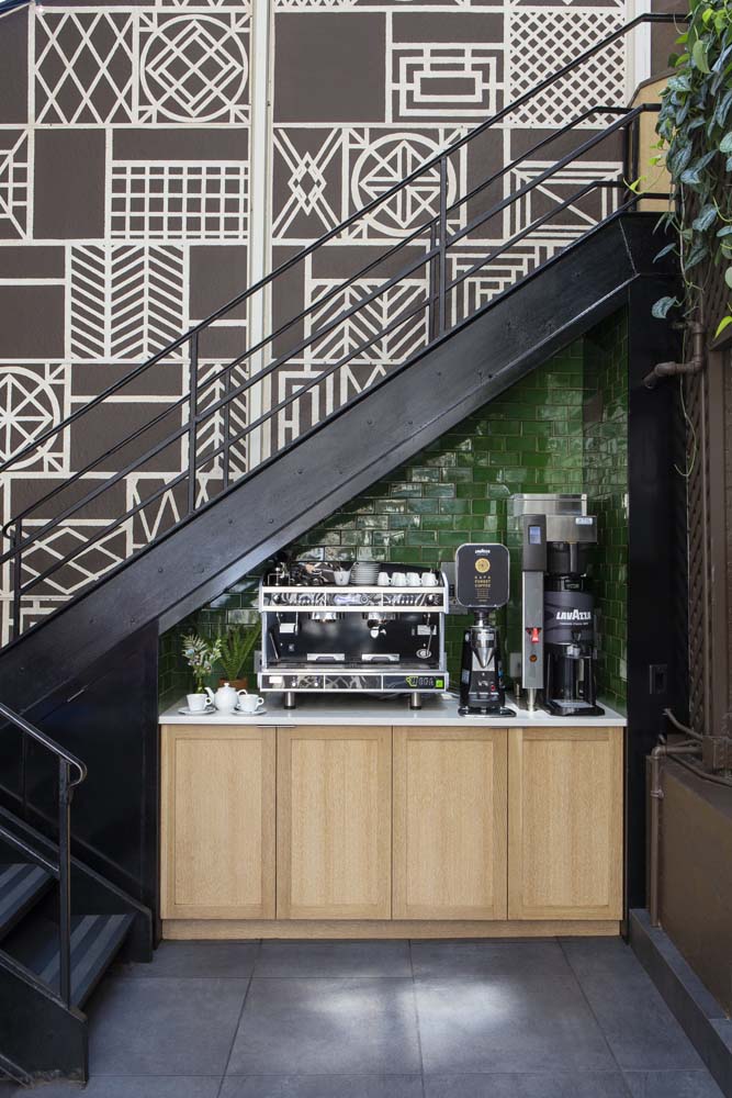 Todo espacinho livre pode virar um cantinho do café: esse aqui embaixo da escada abriga cafeterias profissionais no balcão com armário. 