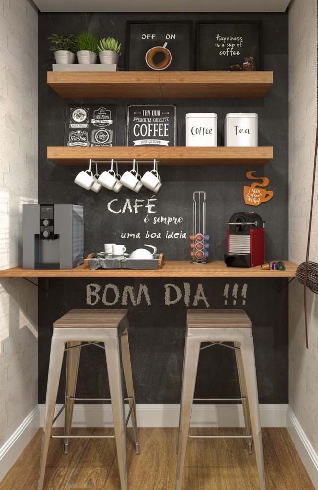 Neste cantinho do café suspenso destacamos a decoração temática com direito a quadrinhos e até mensagens escritas com giz branco na parede preta.