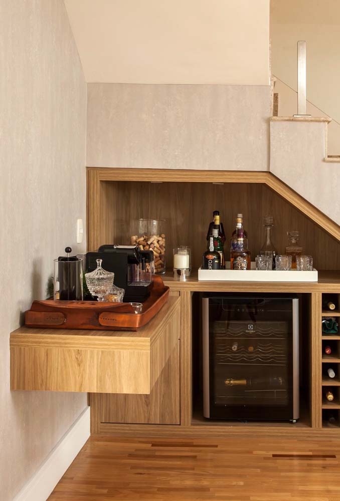 Simples e elegante, um cantinho do café suspenso no aparador com gaveta e próximo à bancada planejada de bebidas alcoólicas.