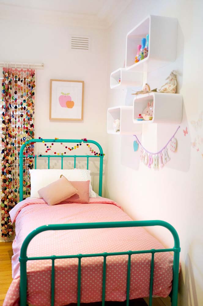 Já neste aqui, a cortina de miçangas grandes e coloridas cobre a janela e combina com o cordão de mini pompons que decora a cama. 