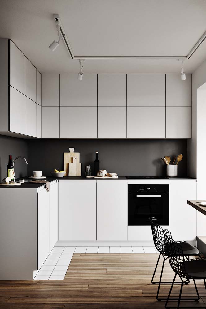 Cozinha preta e branca simples com paredes em contraste com os armários
