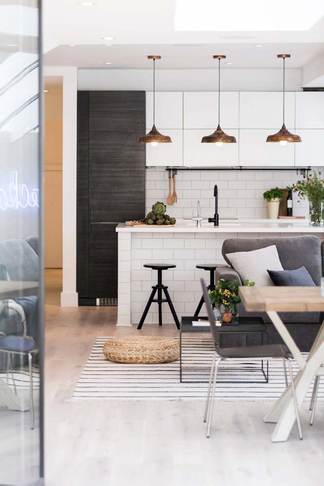 Cozinha americana preta e branca integrada com a sala de estar 