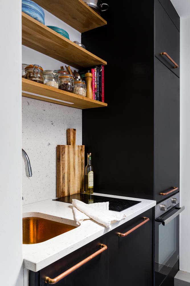 Explore elementos metálicos para glamourizar a cozinha preta e branca