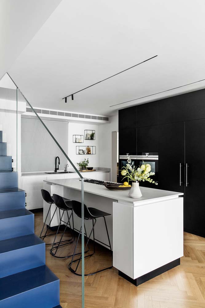 Nessa cozinha planejada preta e branca as cores são bem distribuídas por todo ambiente
