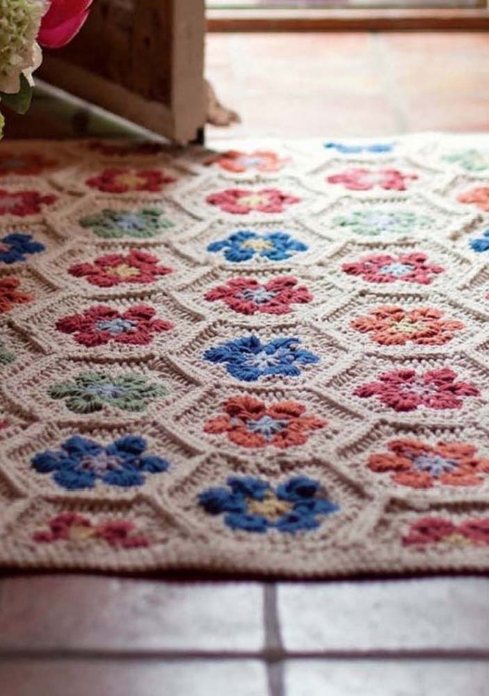 O formato hexagonal aparece também neste tapete de crochê com square de flor delicada para a porta de entrada de casa.