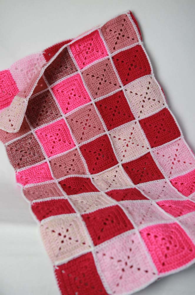 Neste outro modelo de tapete de crochê com square fácil os quadrados são divididos em triângulos por pontos vazados. 