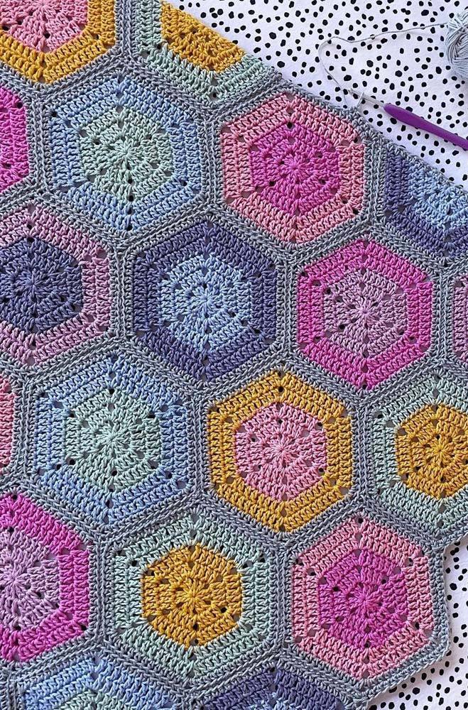 Os hexágonos vão se expandindo e ganham novas cores neste tapete de crochê com square colorido. 