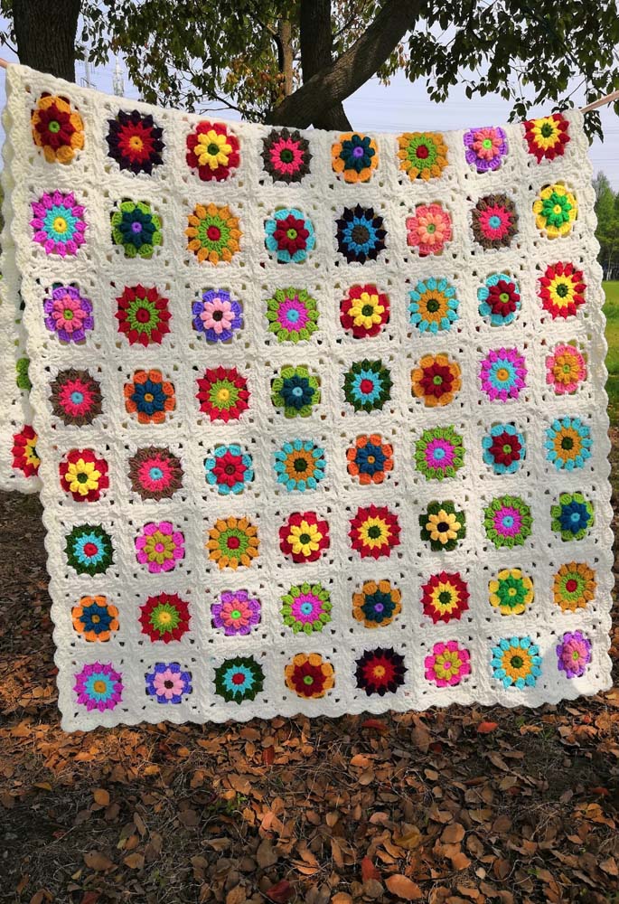 Em cada quadradinho, uma flor diferente neste tapete de crochê com square colorido bem grande e primaveril.