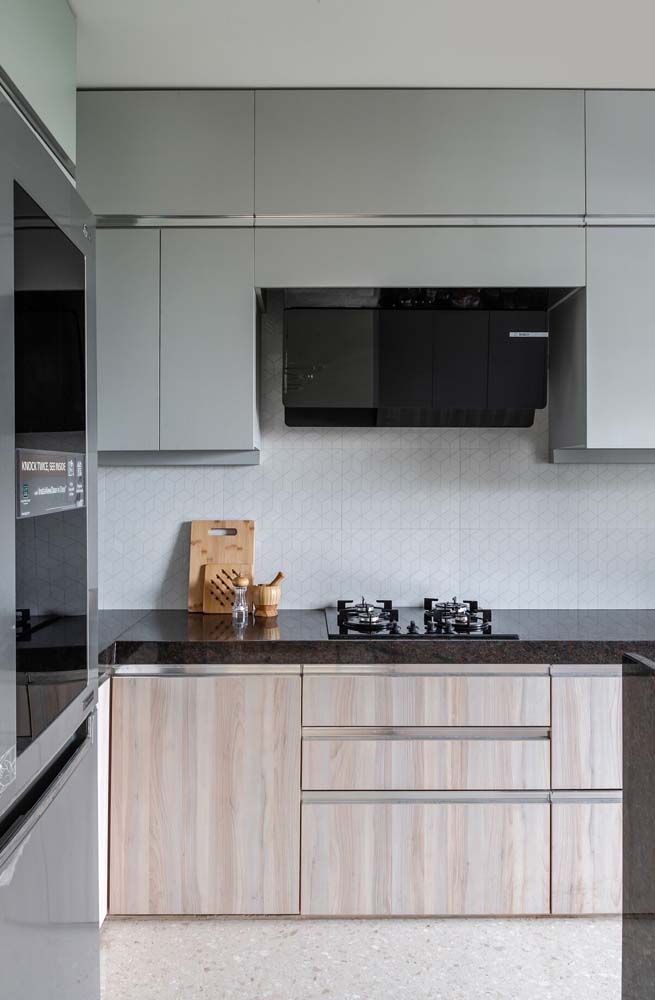 Os tons neutros são o destaque dessa cozinha planejada com bancada de granito preto
