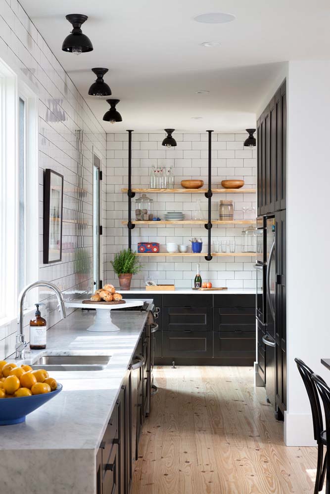 Para quem é fã do estilo industrial uma inspiração de cozinha planejada com bancada de granito preto