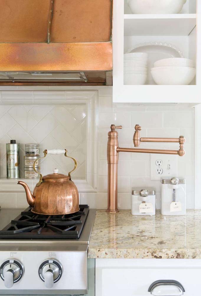 Os detalhes em cobre completam o projeto dessa cozinha planejada com bancada de granito