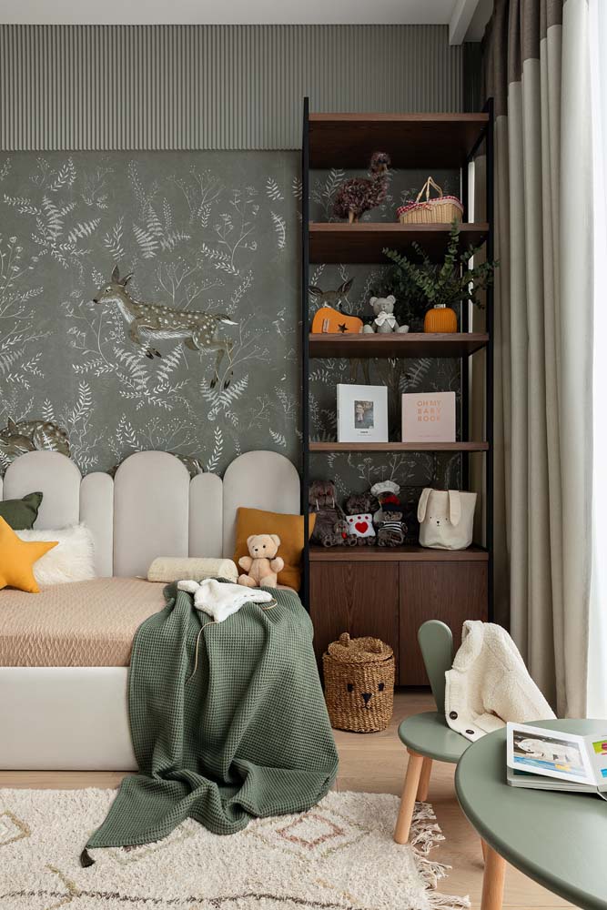 Uma decoração digna dos contos de fada com um toque moderno para esse quarto infantil com tons de verde musgo no papel de parede e cortinas.