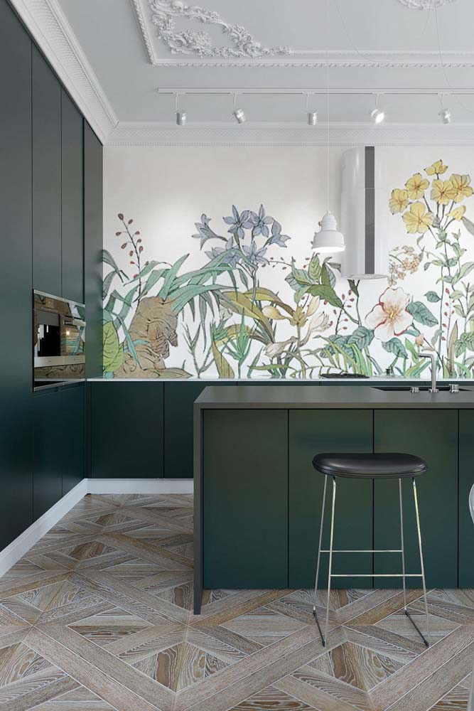 A natureza marca presença nessa cozinha moderna com armários num tom de verde musgo escuro e papel de parede de flores. 