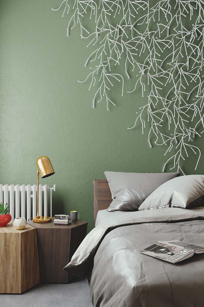 As luzinhas brancas se espalham como galhos de árvores na parede verde musgo desse quarto. 