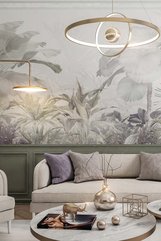 A meia parede com boiserie verde musgo é o bloco de cor de maior intensidade nessa sala de estar elegante e cheia de suavidade com paleta cinza clara. 